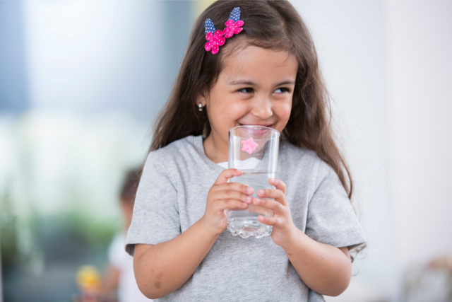 A kislány vizet iszik: a gyermekkori elhízás megoldásai közé tartozik, hogy ne itassunk cukros italokat.