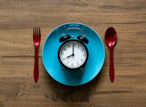 a rendszeres étkezést szimbolizáló óra tányérral és evőeszközökkel
