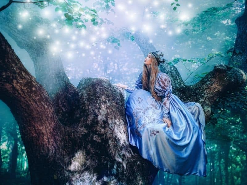 fán ülő hercegnő és varázslatos fények az erdőben