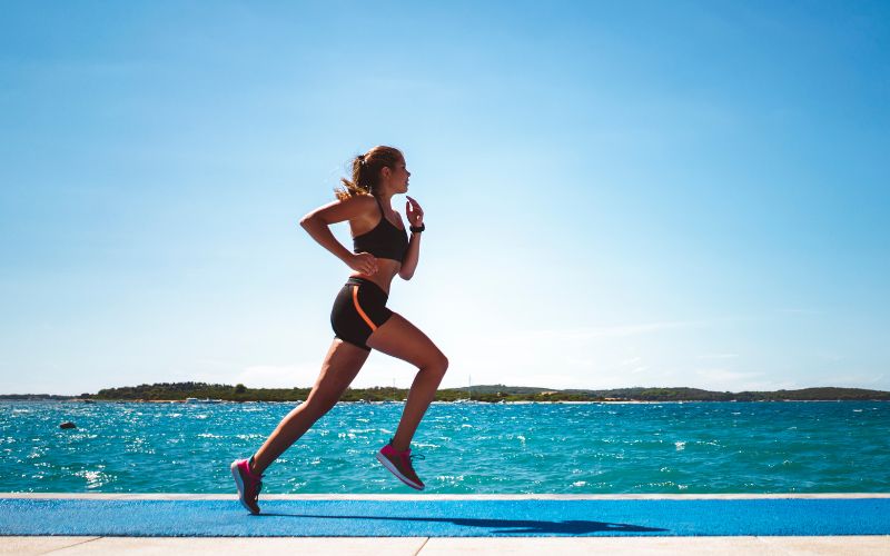 nyári vízparton futó nő