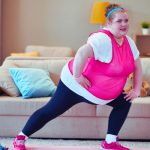 túlsúlyos nő tornázik a szobában